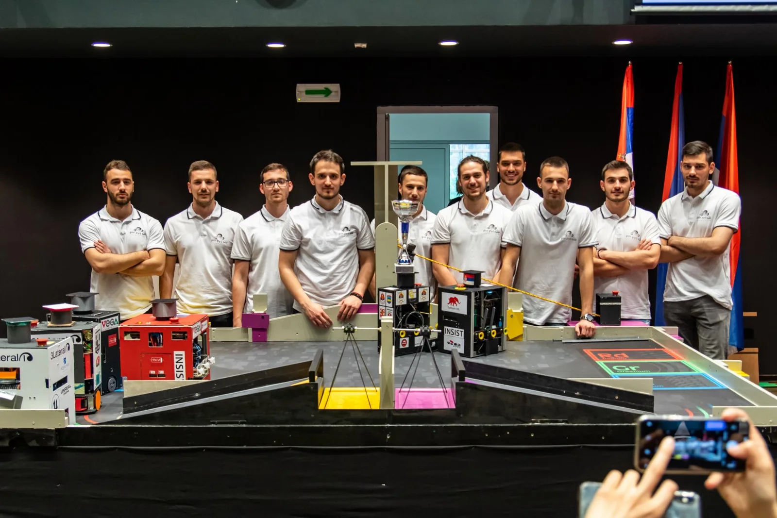 The PMG Robotics team with their robots on the competition field