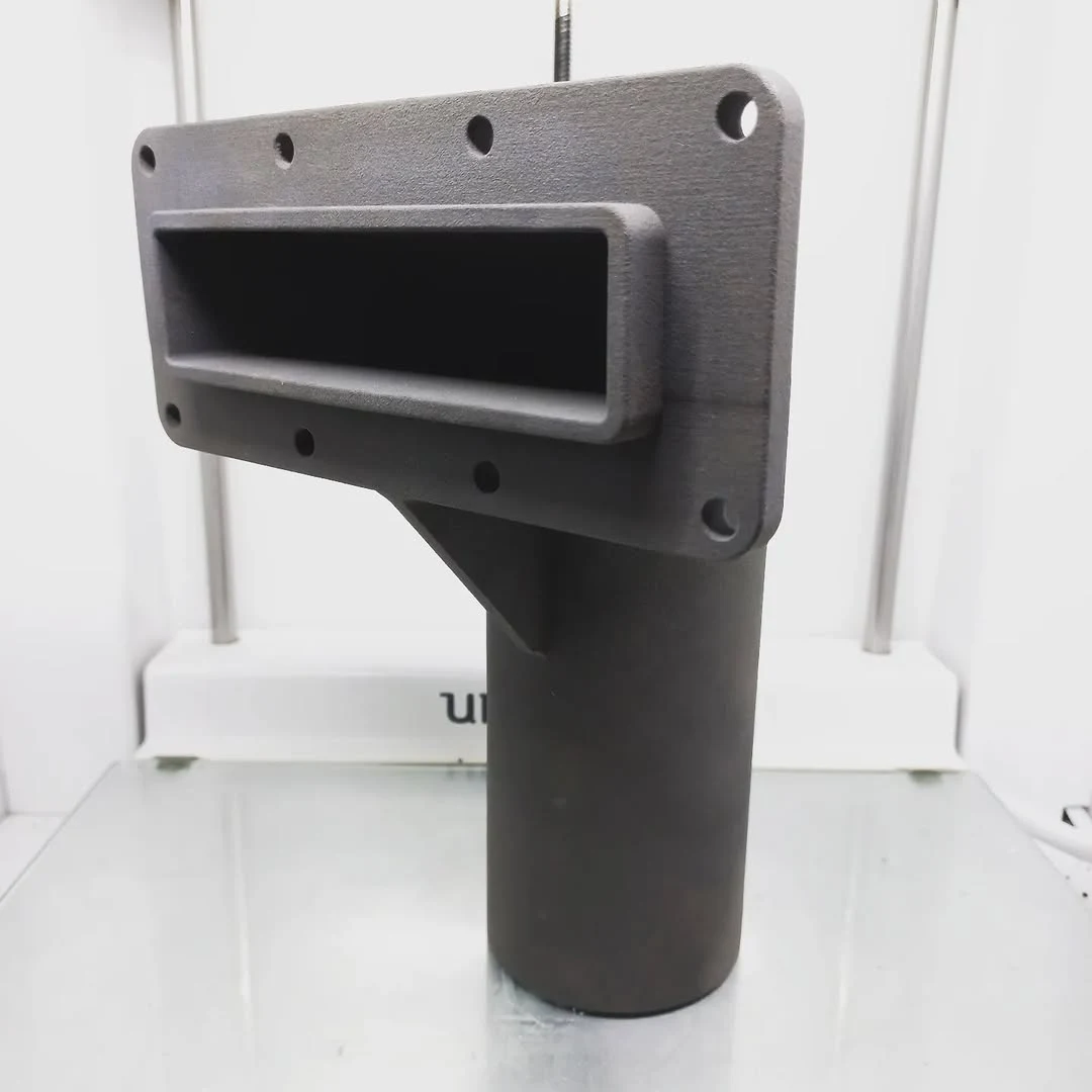Grey functional part with a rectangular flange and a tubular extension, printed with SLS technology in PA12 nylon