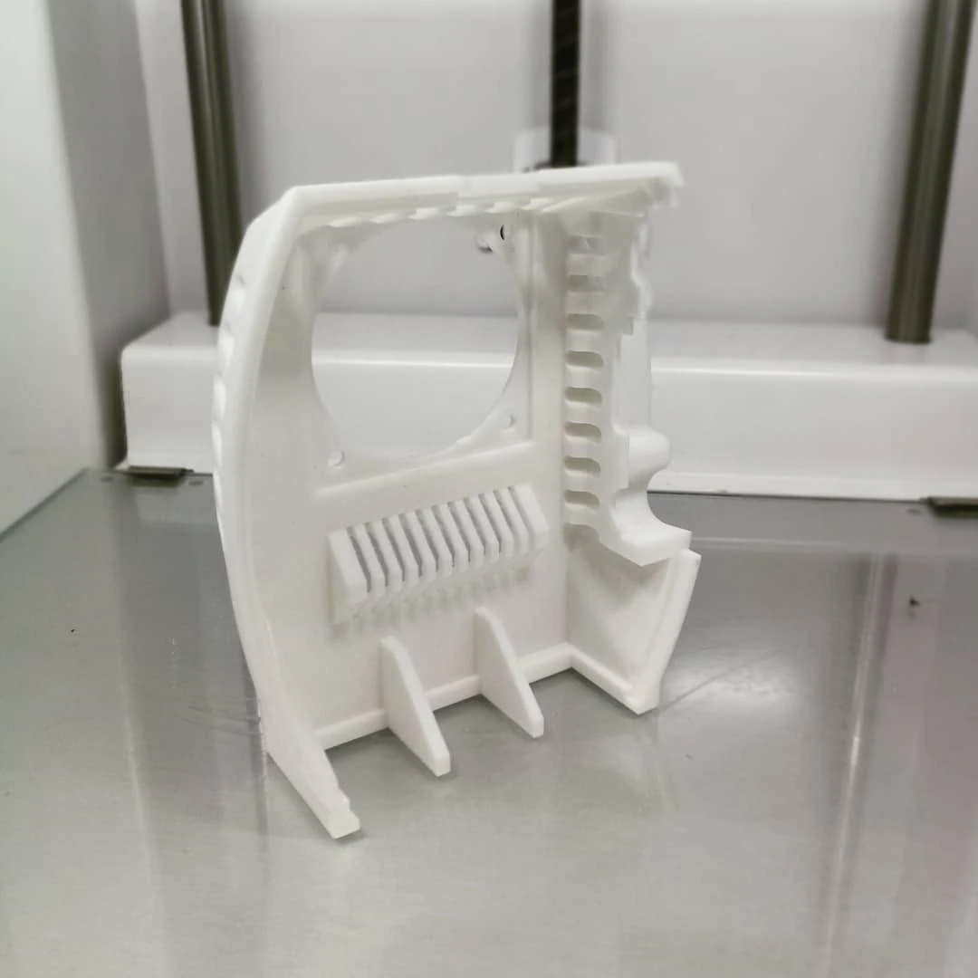 Weißer 3D-gedruckter Prototyp eines Elektronikgehäuses mit Lüfteröffnung und Kühlrippen